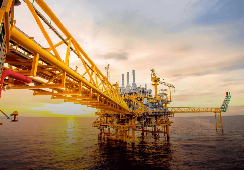 Offshore industrial platform and pipeline at sunset